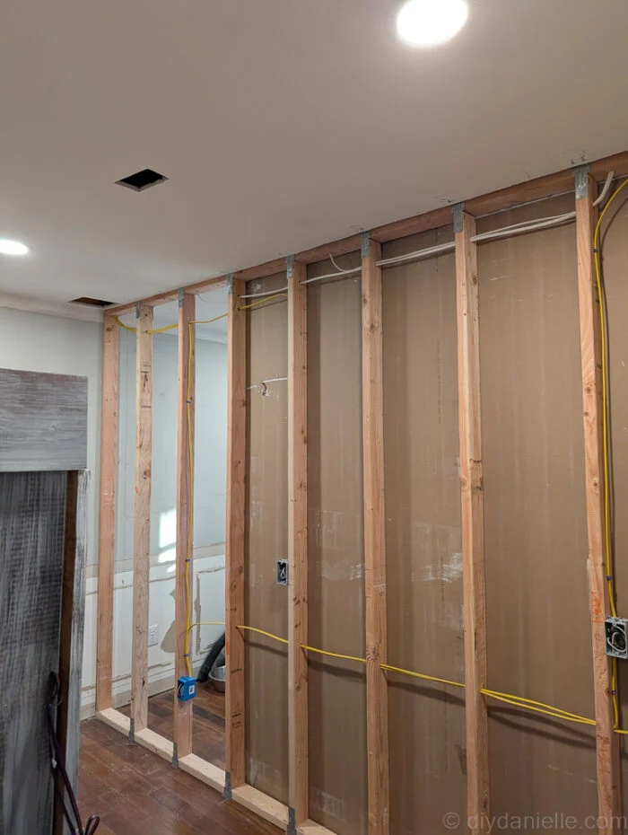 We placed some of our drywall panels before the electrician came: specifically ones that wouldn't interfere with his work. The rest we left off until he finished.