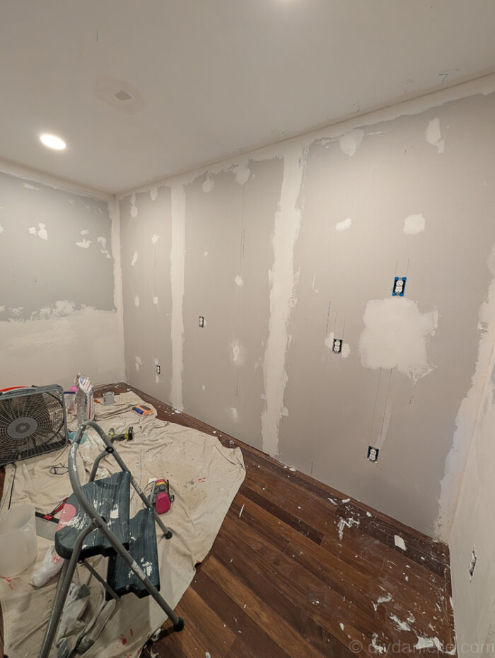 Working on mudding the sheetrock for the new wall. Pantry side.