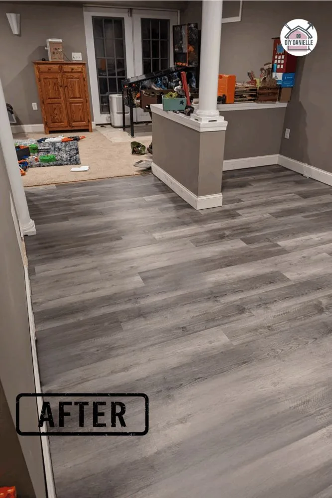 Newly installed laminate flooring in the basement during an emergency Christmas DIY project following plumbing repairs.