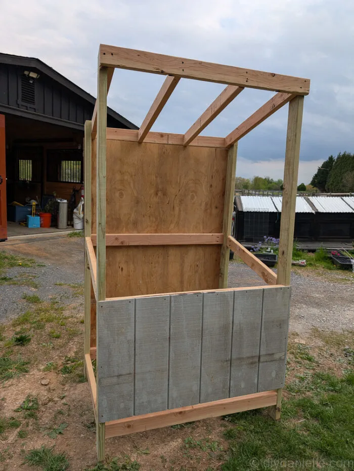 DIY farm stand with T-11 siding panels installed on the sides, back, and front before removal.