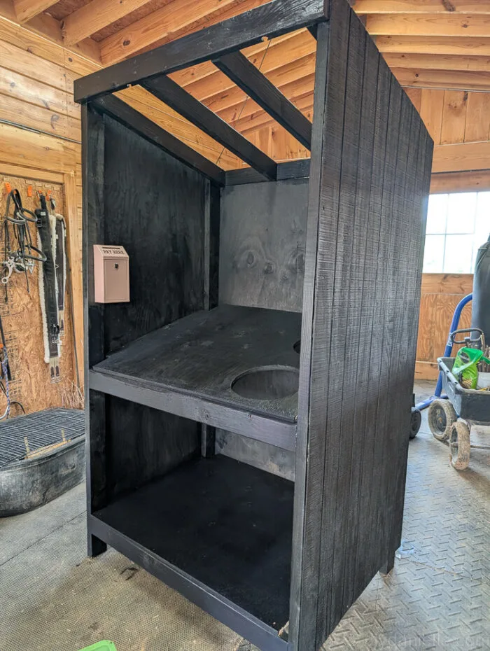 Painted farm stand with mounted cash box securely attached to the wooden frame.