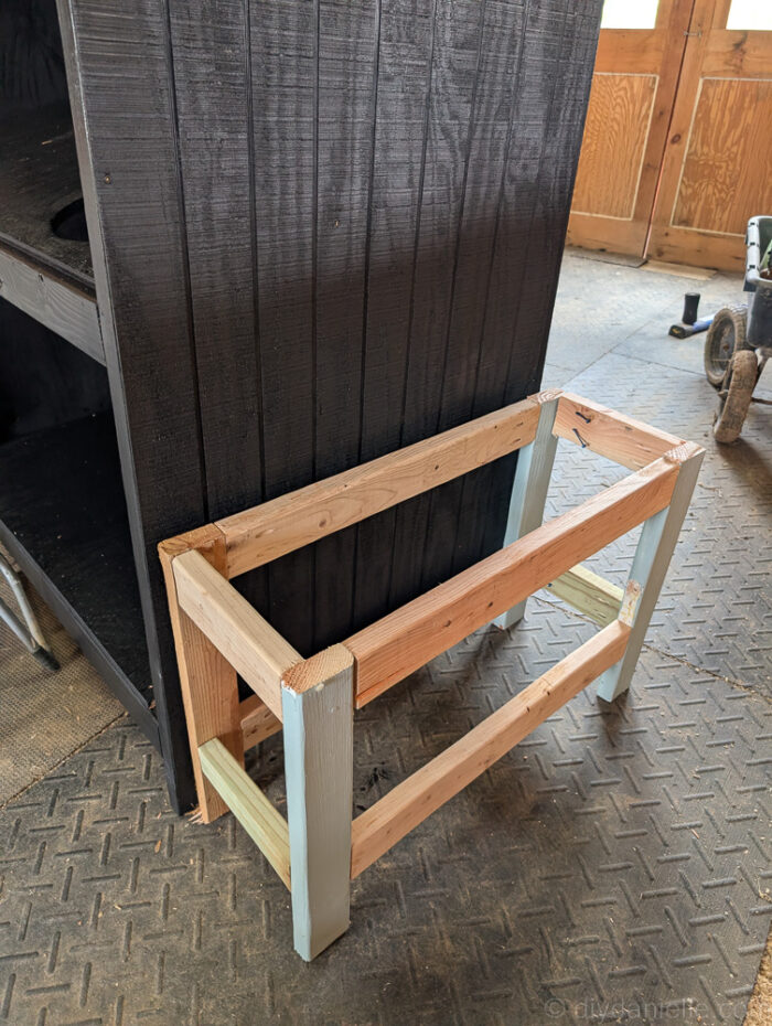 DIY farm stand with wooden side planters attached, ready to be filled with soil and plants.

