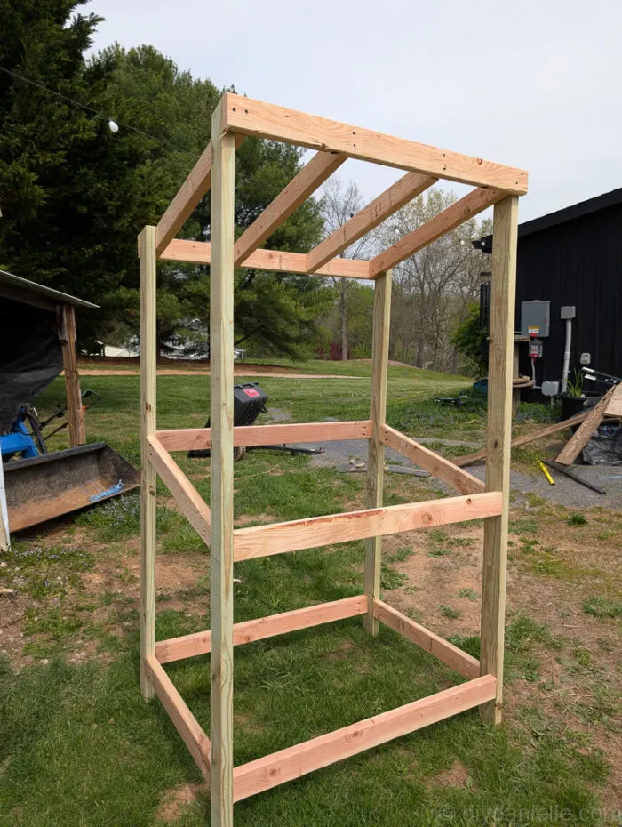 Completed wooden frame of DIY farm stand, ready for shelves and finishing details.