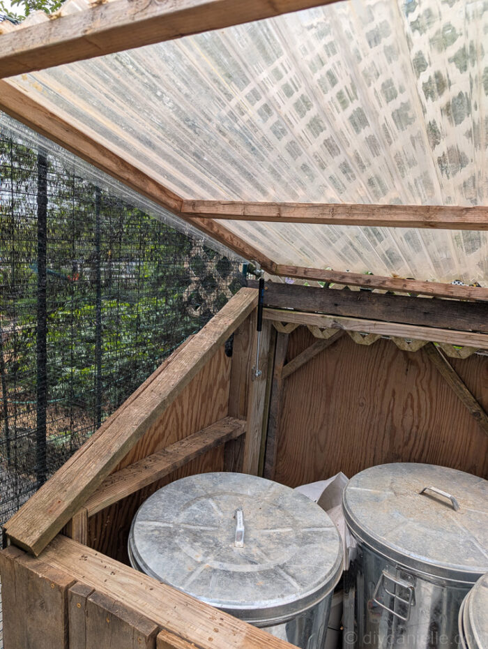DIY feed shed with short access front, designed for metal feed bins with limited movement.