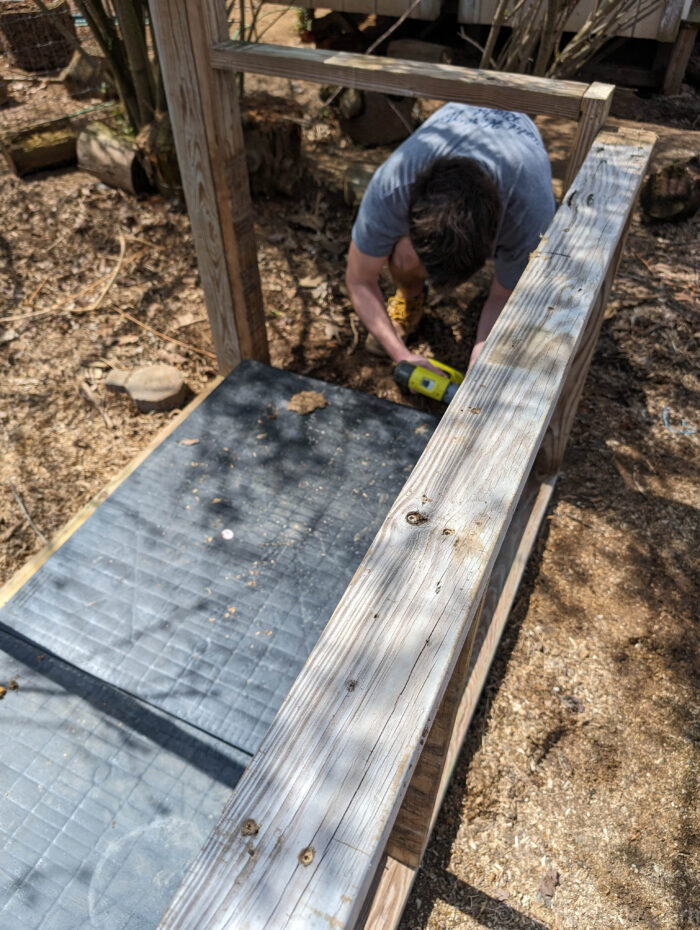 DIY feed shed built around plastic pallets to elevate feed bins and protect them from moisture.