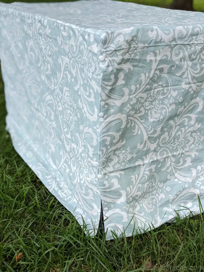 Close-up of snaps and Velcro attached to fabric panels on a DIY dog crate cover for easy removal.