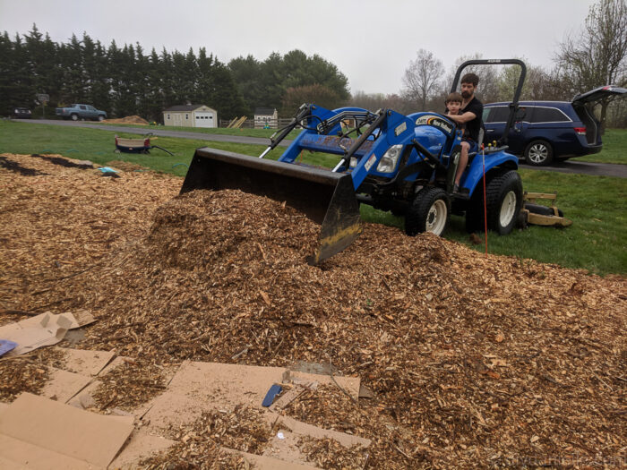 Close-up of heavy wood chip mulch pile with garden tools.