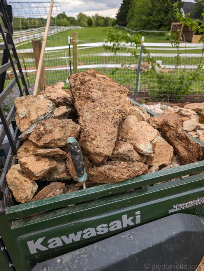 Placing foraged rocks around the pond edge to secure the liner and create a natural look.