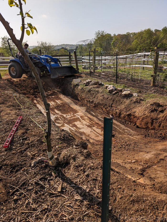 Digging a backyard pond with a tractor and hand tools, creating deep center for fish and shallow plant shelves.