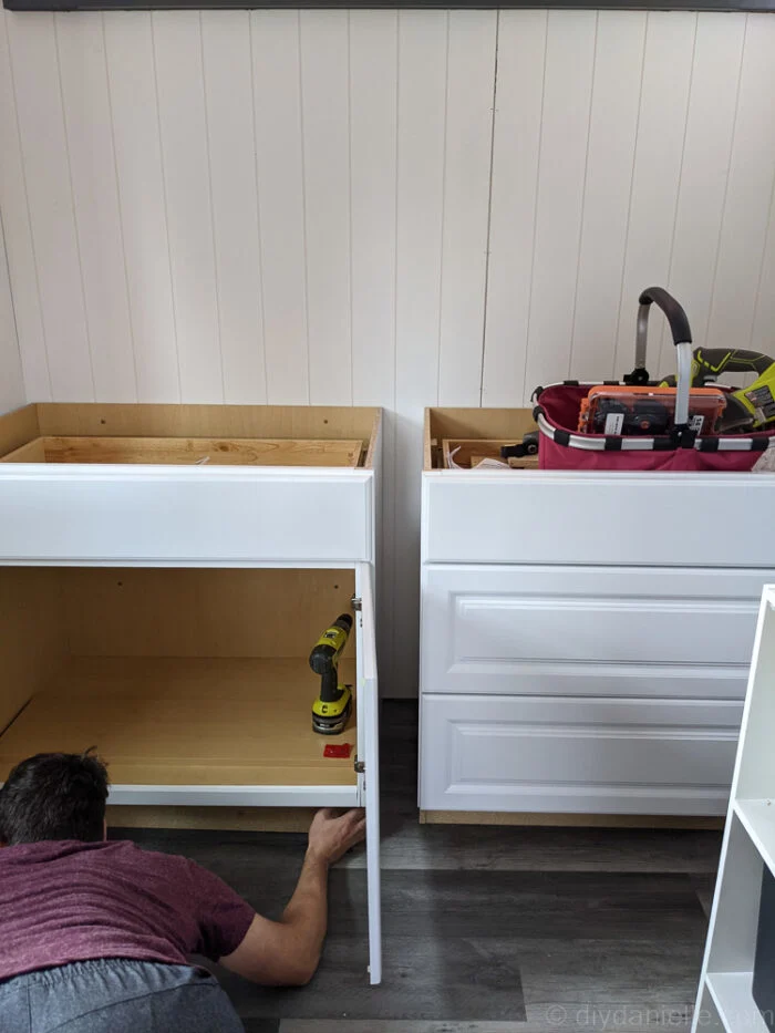 DIY cabinet installation showing screws into wall studs
