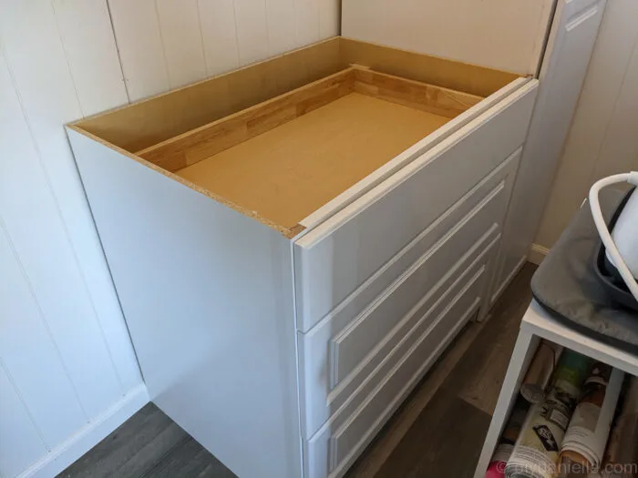 Kitchen storage solution with base cabinet next to pantry cabinet