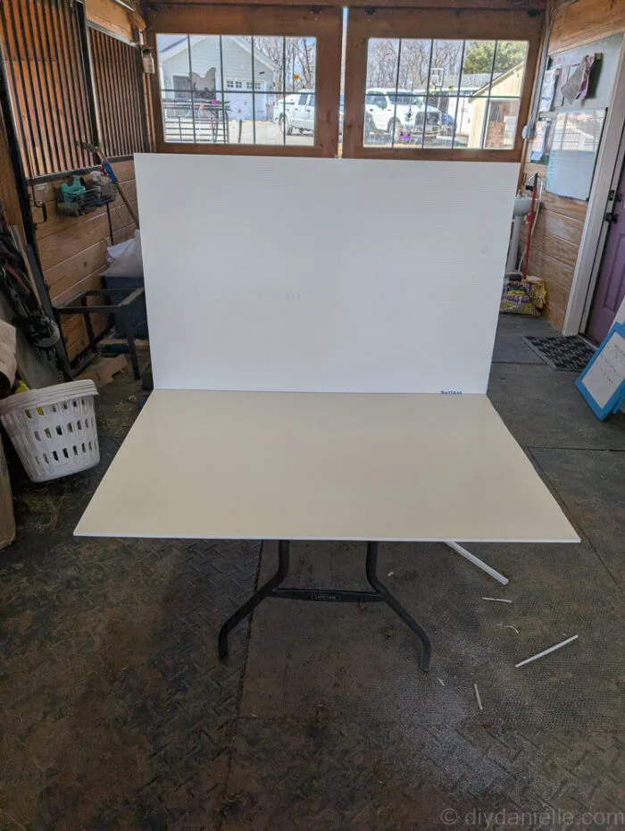 Cut PVC board pieces including bottom, sides, and back to fit inside a Critter Nation cage for a durable DIY base.