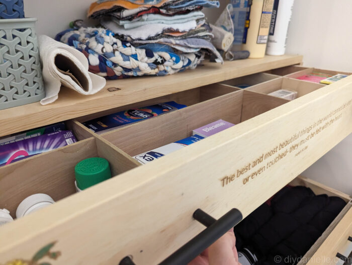 Close-up of hands attaching drawer pulls on a wooden drawer front.