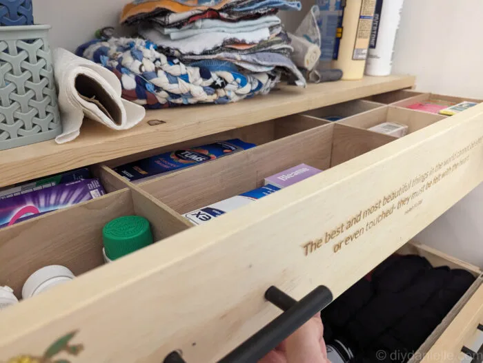 Close-up of hands attaching drawer pulls on a wooden drawer front.