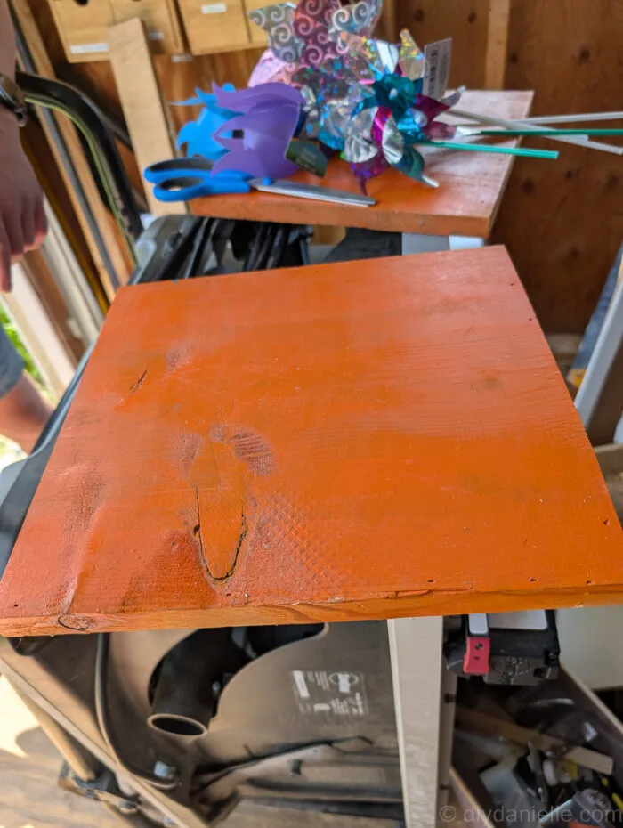 Wood board being sanded and prepped as the base for a DIY sequin fabric fidget board.