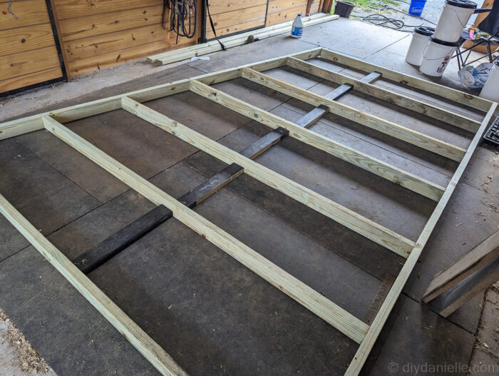 Back frame of a run-in shed with horizontal boards added between vertical supports for added stability.