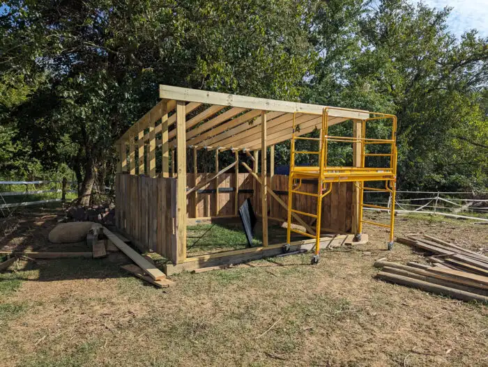 Close-up of roof framing connecting to a header board on the front of a run-in shed.
