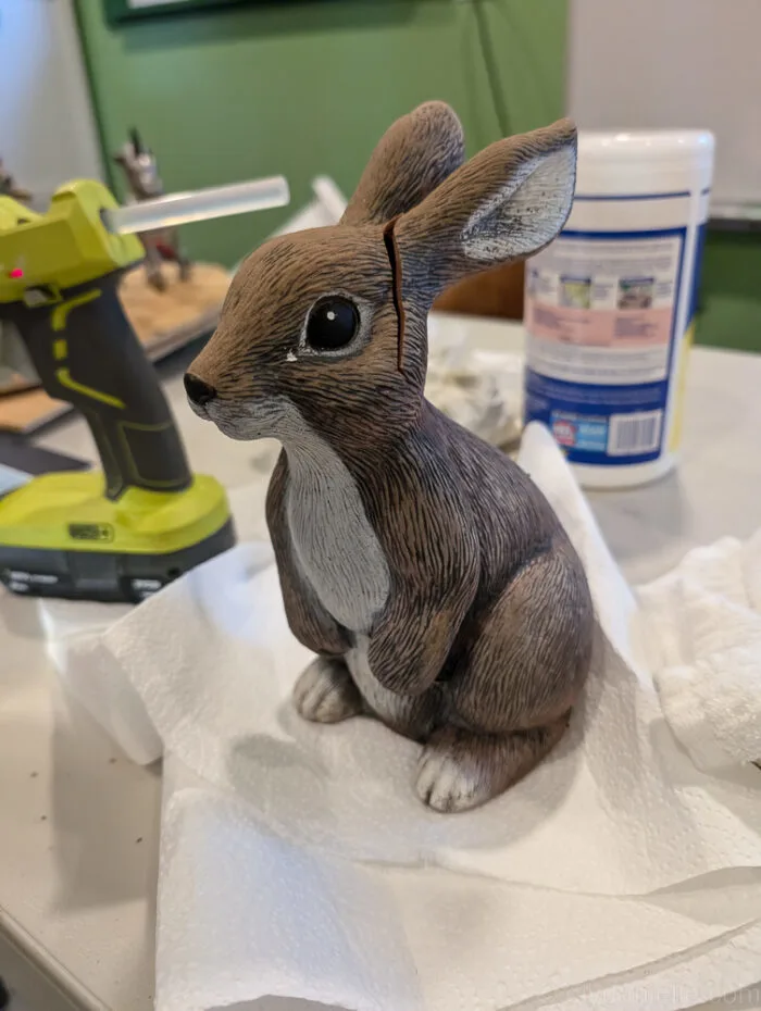 Close-up of a painted zombie rabbit statue with weathered effects and spooky textures.