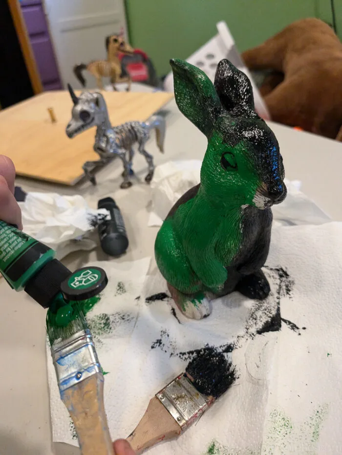Side view of upcycled garden bunny statue turned into a zombie with paint and Halloween effects.
