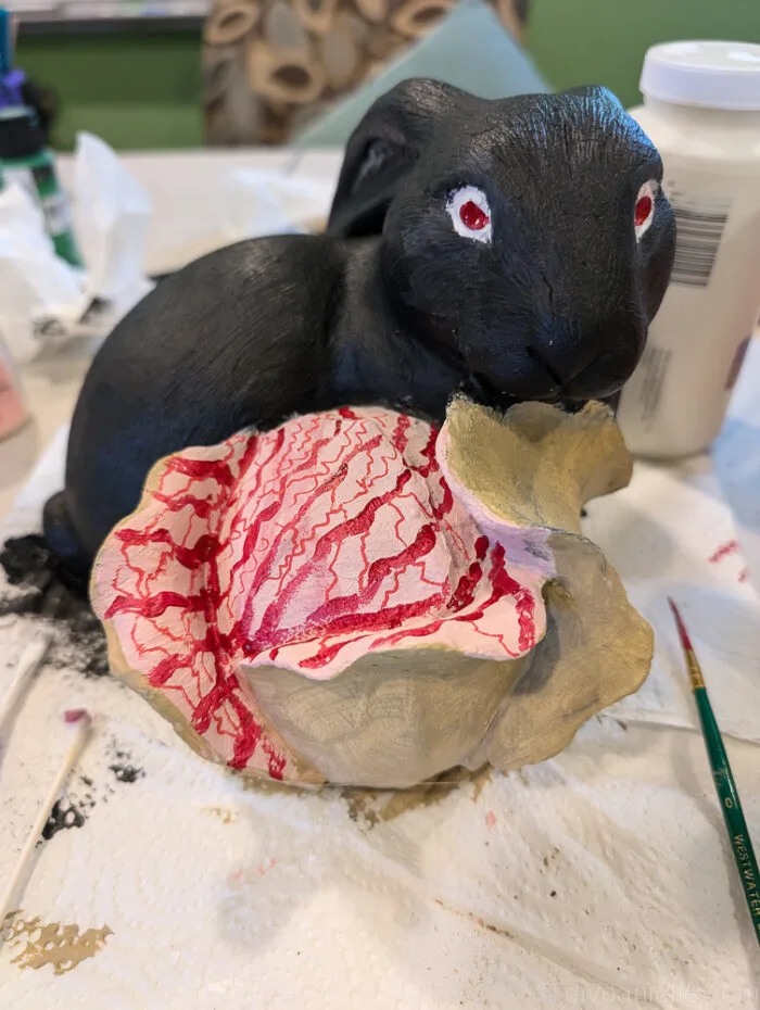 Multiple zombie bunny statues arranged in Halloween yard setup with fog and props.