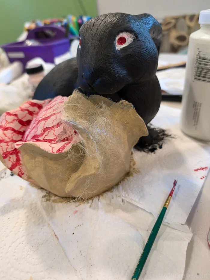 Before and after of garden bunny turned into zombie with paint and Halloween details.