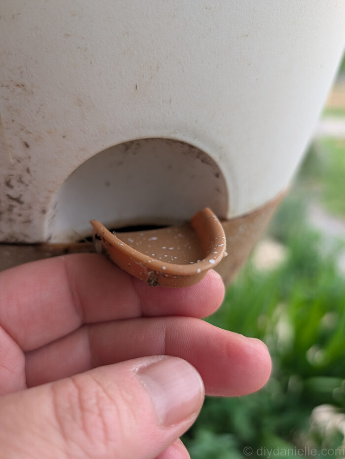 Close-up of a self-watering planter showing the string wick that pulls water from the base to the soil.