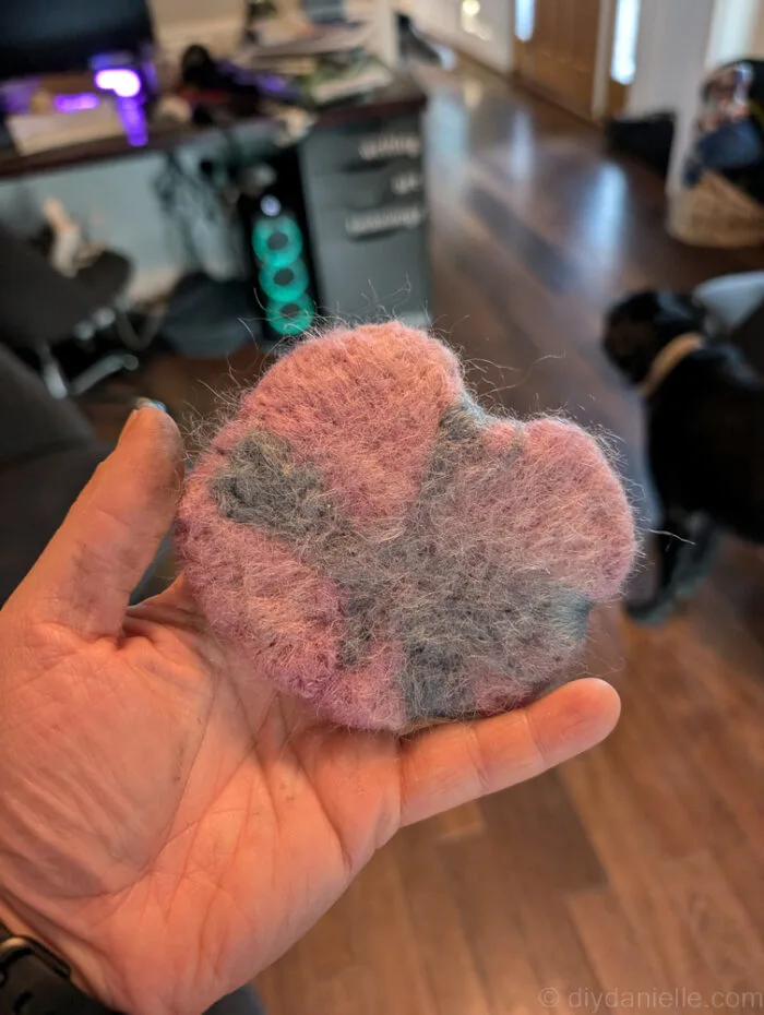 Flat, fuzzy needle felted catnip toy in a round shape with visible wool texture