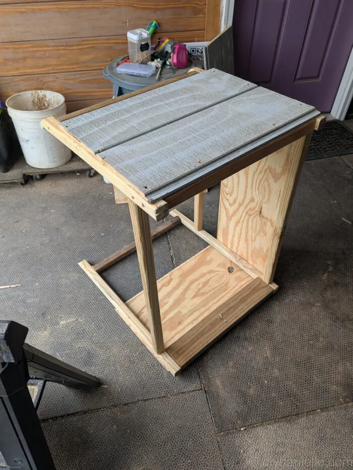 Partially sided outdoor litter box cover using scrap T-11 wood panels with gaps for ventilation.