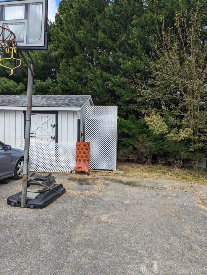 DIY privacy screen leaning against a shed, showing a top-heavy design and need for secure mounting.