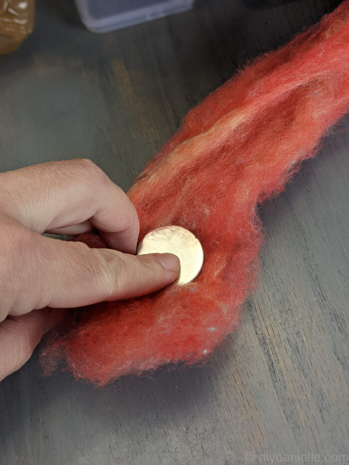 Placing a small magnet inside wool roving before rolling it up for a needle felting project