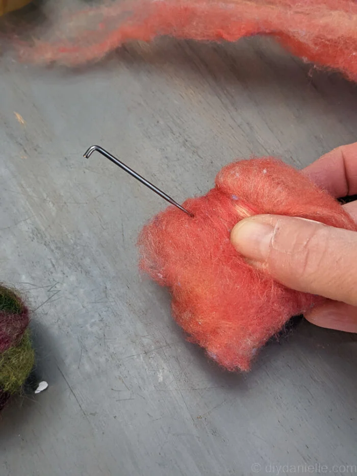 Beginning a needle felting project with barbed felting needle and unshaped wool roving