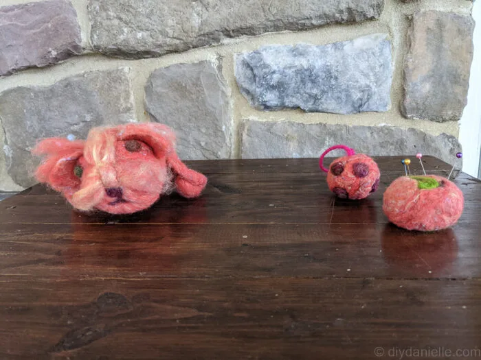 Handmade needle felted ball ornament with protruding wool pieces resembling a COVID model