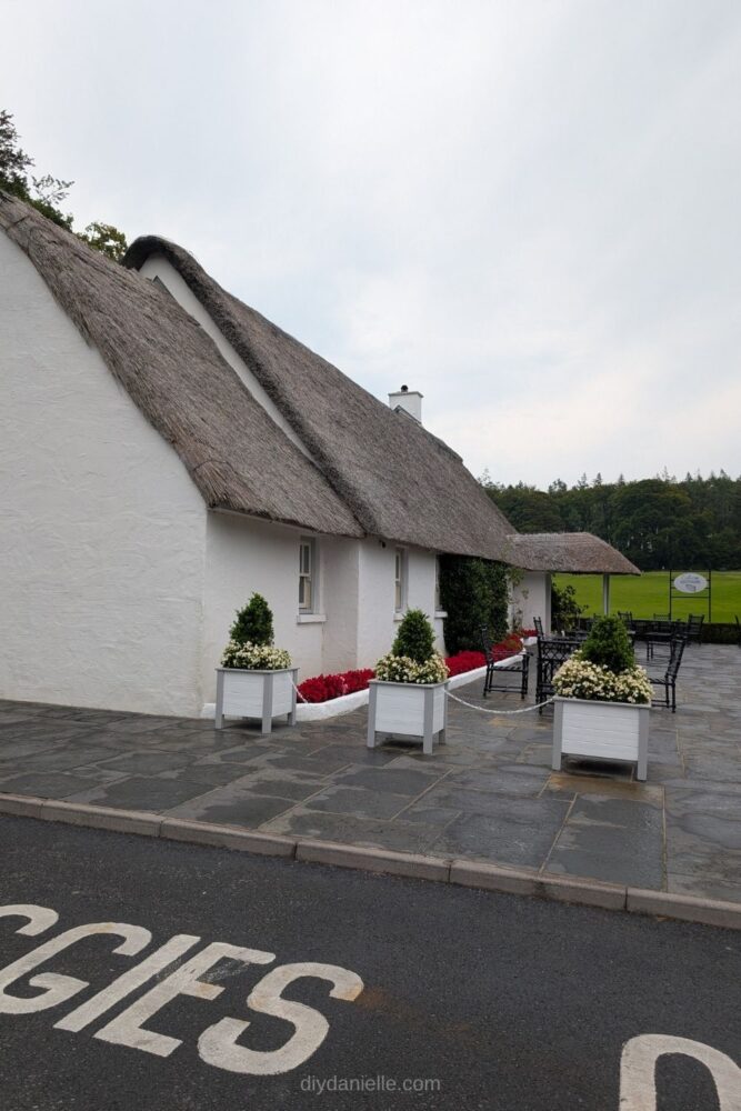 Exterior view of the café at Ashford Castle in Ireland, showing outdoor seating and castle grounds.