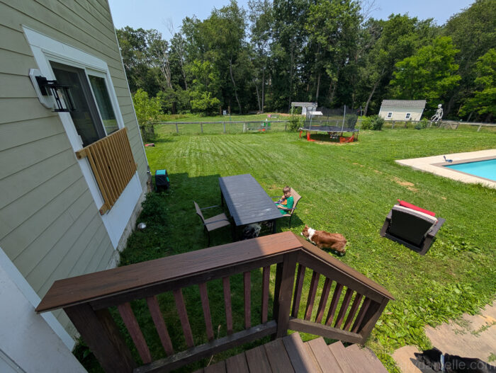 Backyard staged with chairs and layout markers to visualize the size and spacing of a future deck before construction.