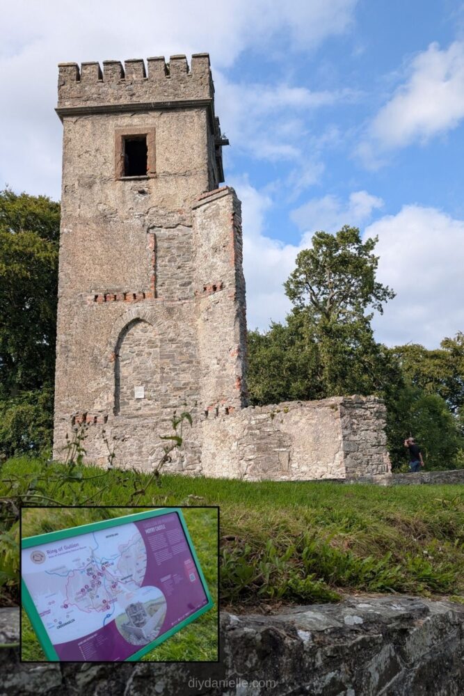Ruins of Moyry Castle atop a hill in Northern Ireland, surrounded by green landscape.