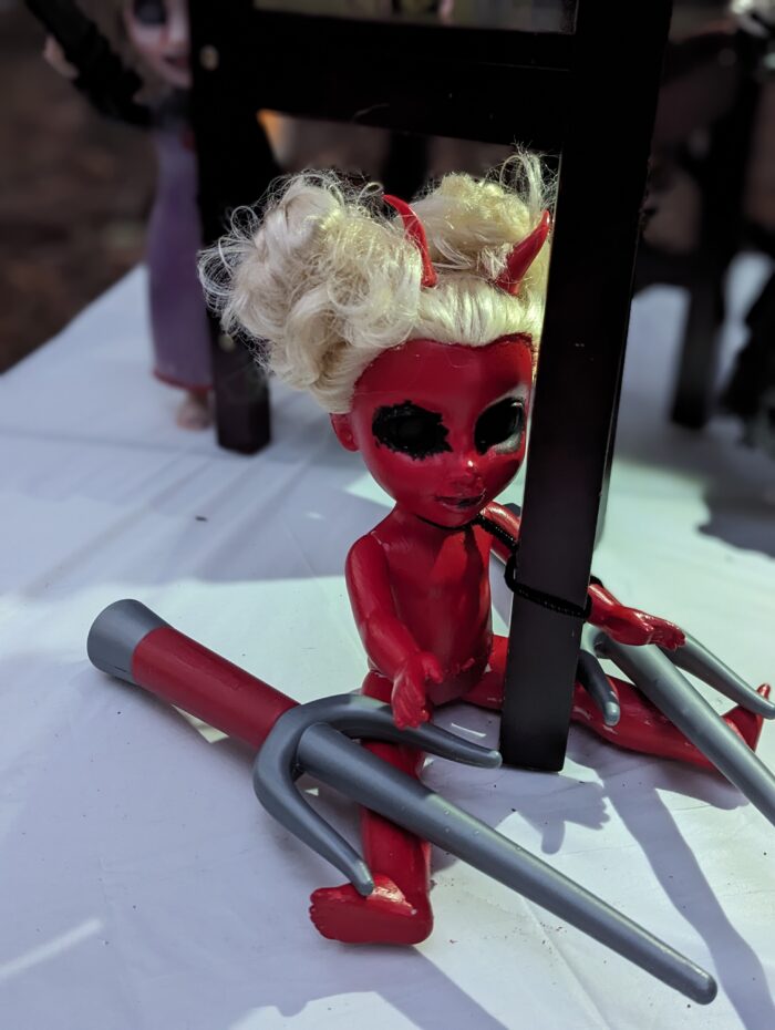 Red doll at the Halloween tea party for an eerie touch.