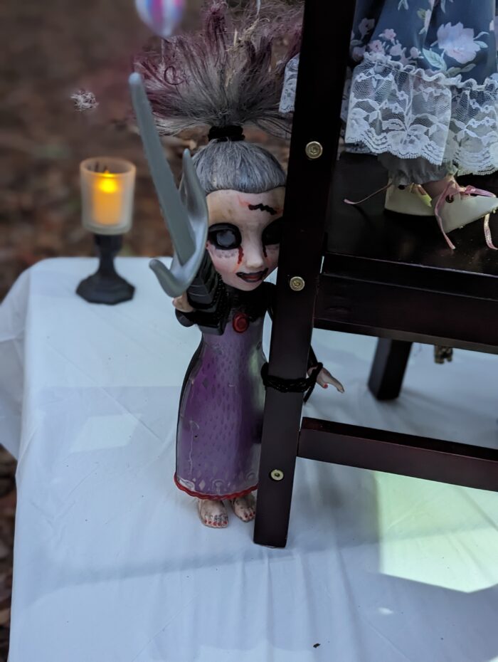Doll wearing a purple dress at the Halloween tea party setup.