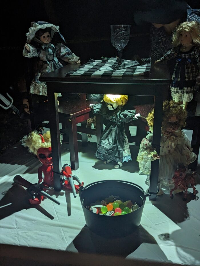 Two dolls posed with a cauldron, creating a witchy Halloween scene.