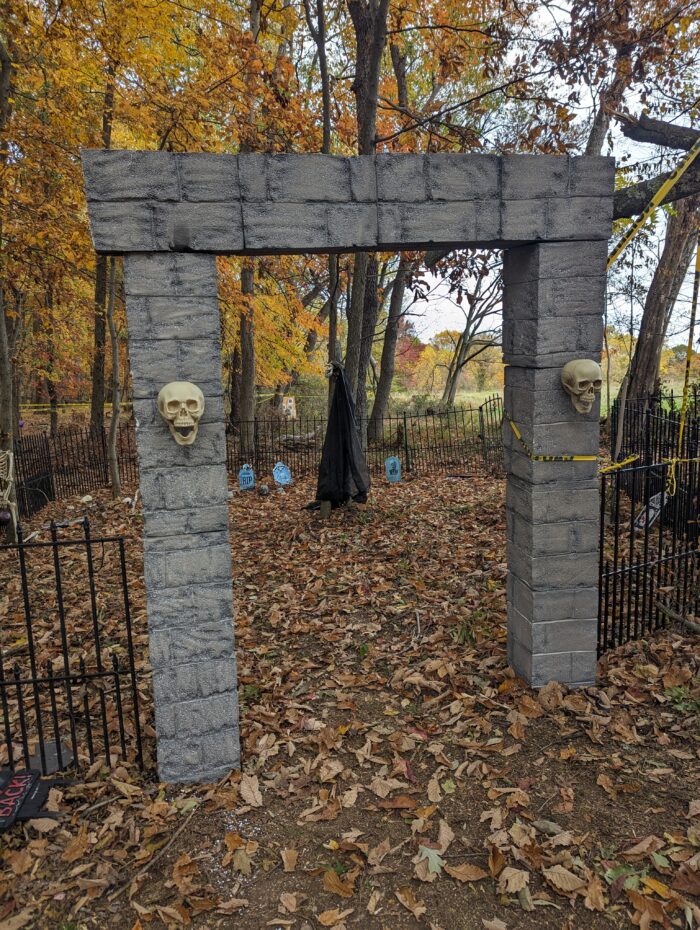 Expanded Halloween graveyard setup with arches and additional grave decorations, creating a spooky and immersive outdoor display.