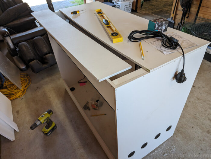 Top of a DIY ball python enclosure showing two PVC pieces joined together, with tips on why using a single piece can simplify lighting installation.