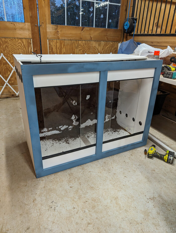 Acrylic doors being installed on a DIY ball python enclosure, providing secure access while keeping the habitat enclosed.