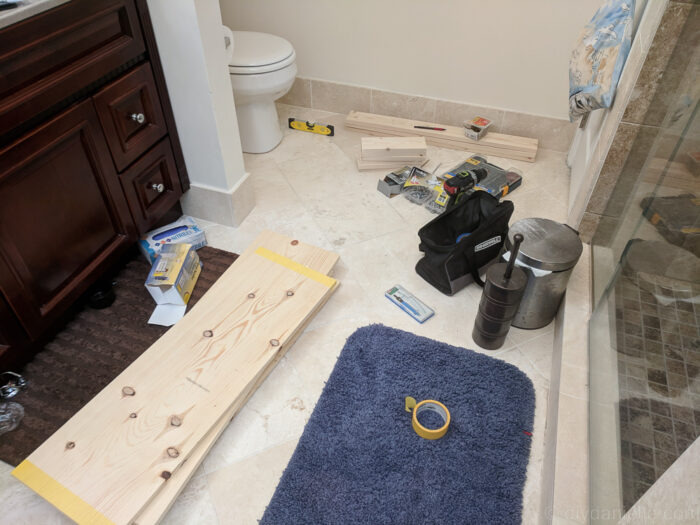 DIY over-the-toilet storage project with supplies laid out, ready for assembly to create functional and stylish bathroom storage.