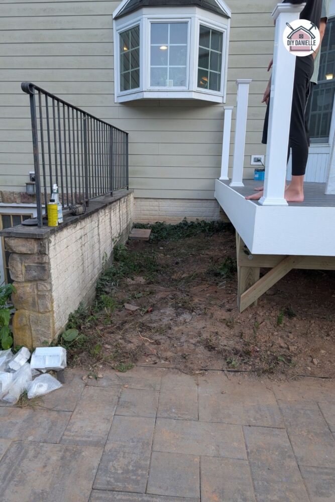 Gap between deck and steps with mud, dirt, and a little grass showing where low-maintenance filling solutions are needed.