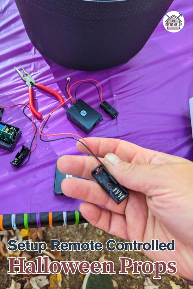 Diagram showing the setup of remote-controlled Halloween props, including battery case holders, wireless relay transmitters, labeled wiring, animatronic props, and remote control for easy operation.
