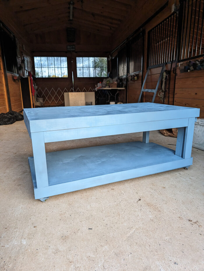Blue reptile enclosure stand with casters installed and painted, showing a durable and mobile base for easy movement of heavy tanks.