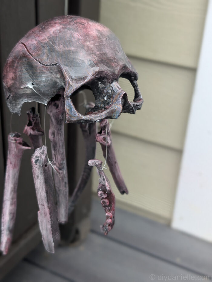 Front view of a DIY skull baby mobile hanging, showing the arrangement of skull pieces for spooky décor.