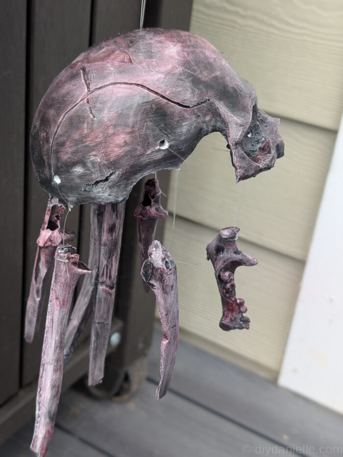 Back view of DIY skull baby mobile, showing how skull pieces are tied and arranged for Halloween décor.