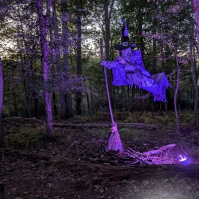 Step-by-step photo tutorial showing how to set up a 12 ft. hovering witch Halloween decoration in a yard display.