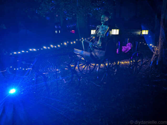 Outdoor Halloween trail at night with lit props and animatronics creating a spooky atmosphere.