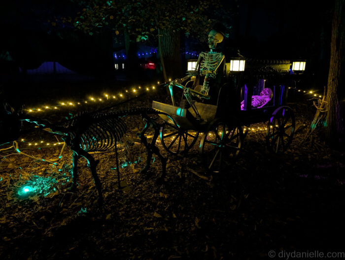 Outdoor Halloween trail at night with lit props and animatronics creating a spooky atmosphere.